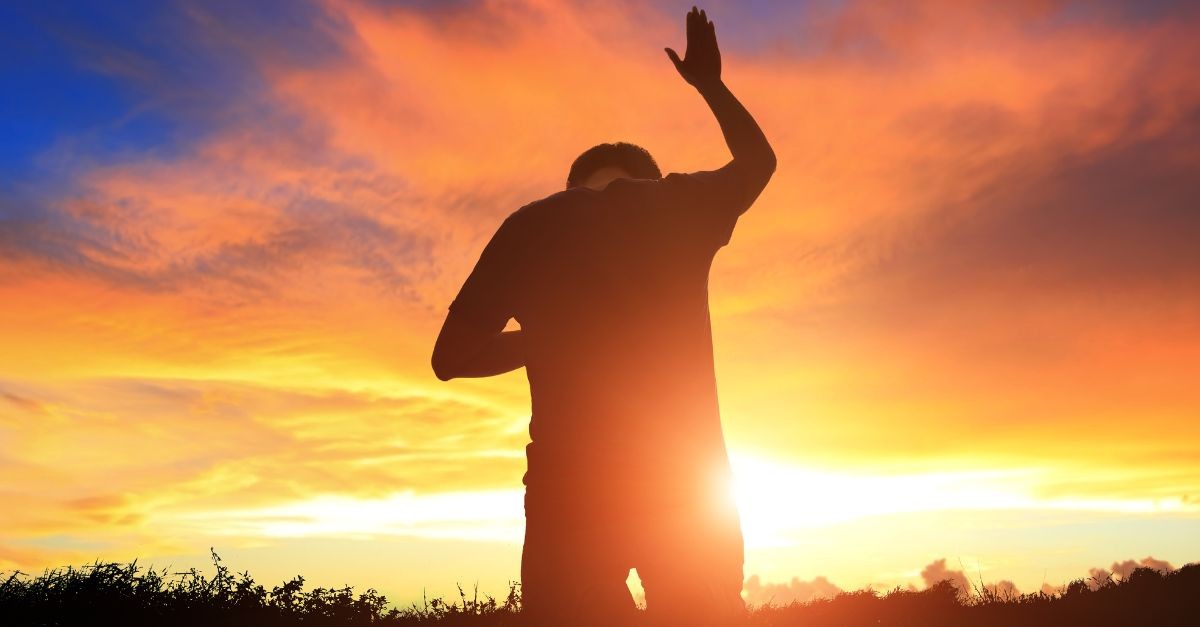 Man in worship outside during sunset.