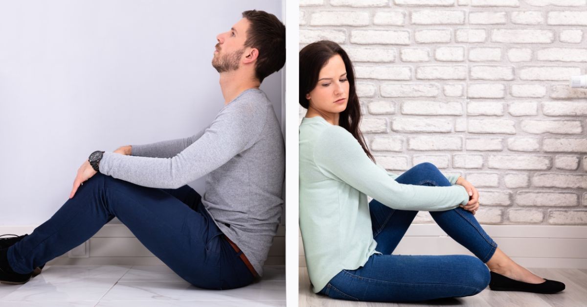 Married couple sitting with their backs up against the wall.